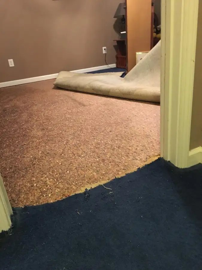 Carpet pad removal revealing water damage during Water Mitigation Services in McNair